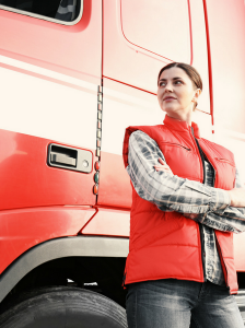 Woman standing with arms crossed in front of truck