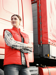 woman standing with arms crossed in front of truck