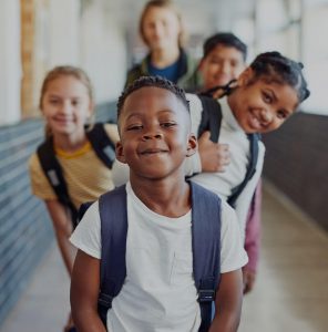 Students smiling in a school hallway.