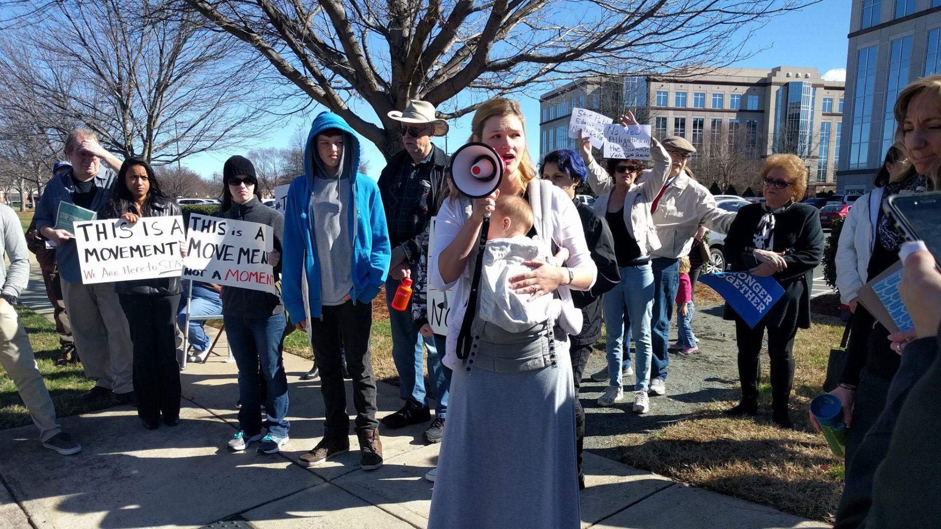 A woman with a baby speaking at a protest