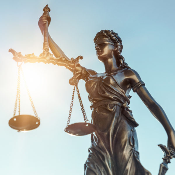 A statue of Lady Justice holding the scales of justice in one hand and a sward in the other.